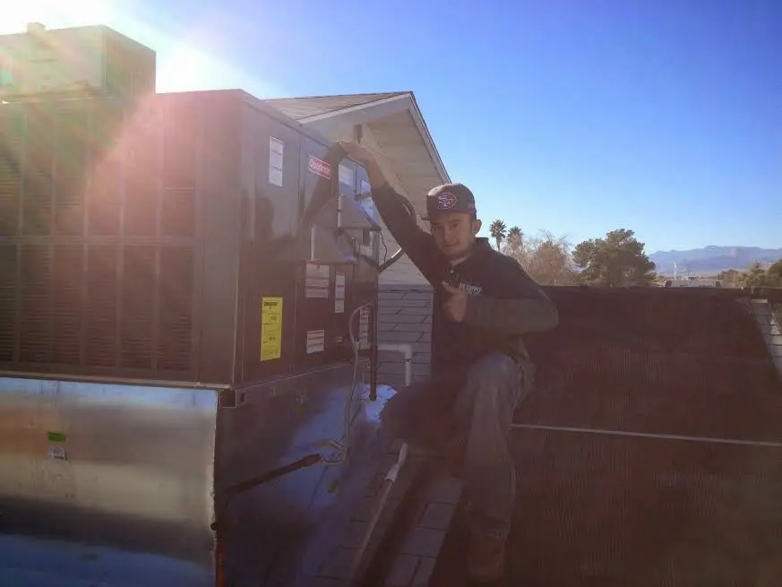 HVAC technician performing Heat Pump Repair on a rooftop unit in Lamar